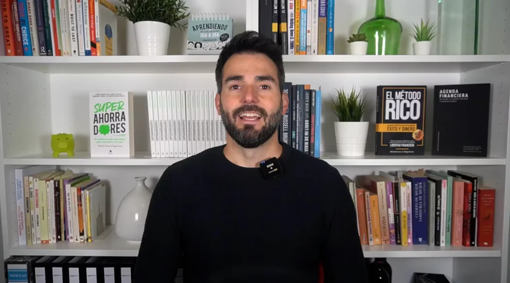 Richard Gracia explicando si el curso Método Rico vale la pena, con los libros Superahorradores y El Método Rico en su estantería