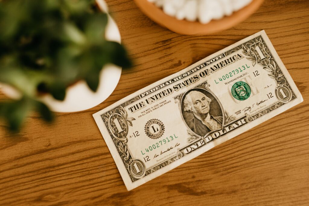 Billetes de dólar sobre una mesa de madera, simbolizando el acceso a capital para operar mediante cuentas fondeadas.